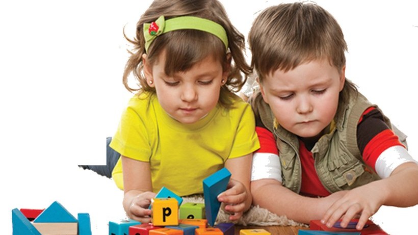 Two children playing and learning with colourful alphabet and number blocks